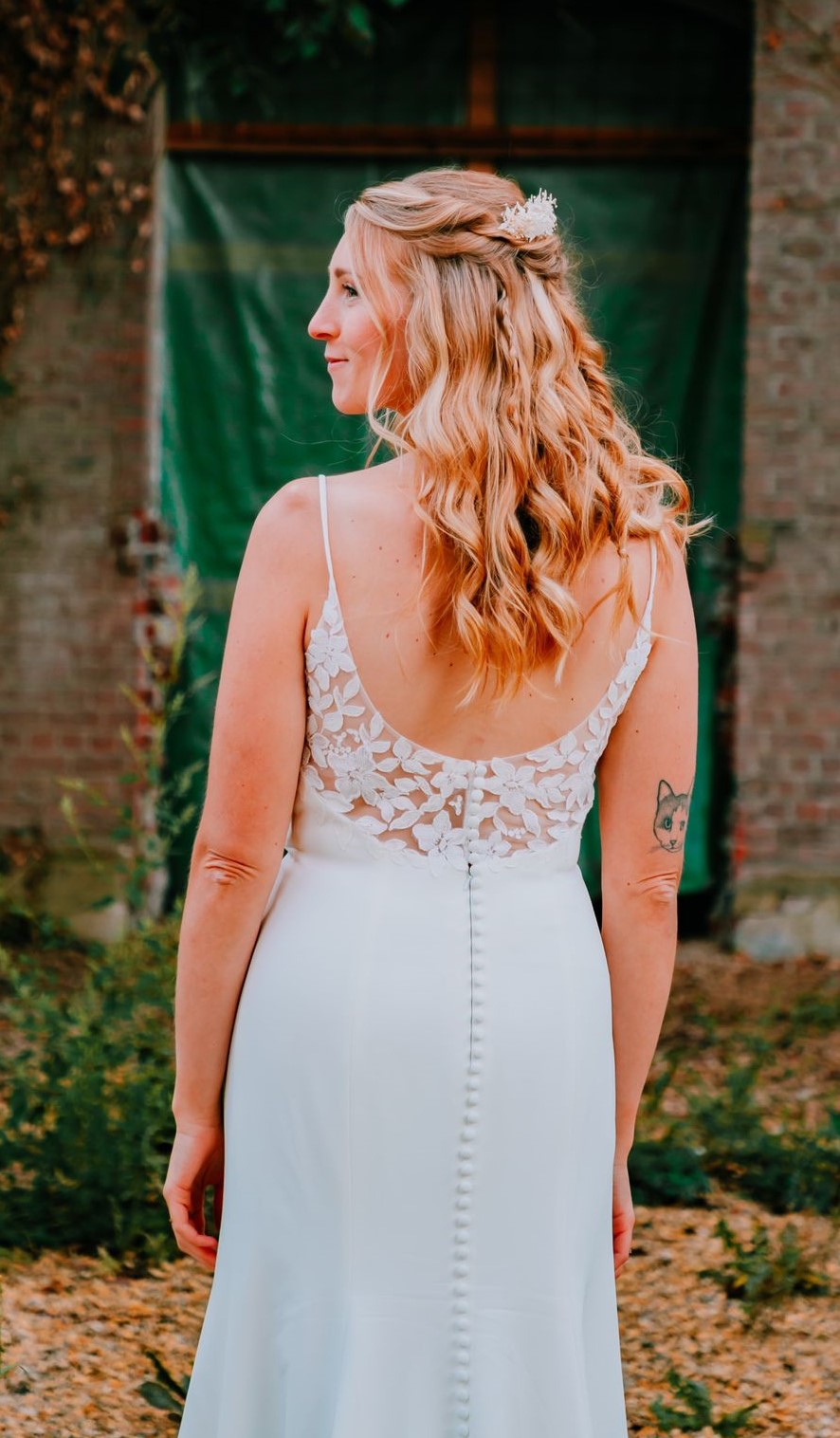 backview of bride with blond curls and white dress looking to the left